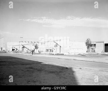 An image from the Convair/General Dynamics Astronautics Atlas Negative Collection showing a close-up view of the Atlas missile on a test launch pad. Ground support personnel are visible in the background. Stock Photo
