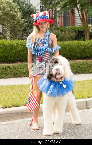 A young girl dressed in patriotic colors poses with her dog during the I'On community Independence Day parade July 4, 2016 in Mount Pleasant, South Carolina. Stock Photo