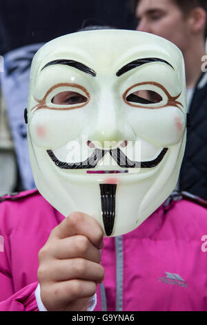 Belfast, UK, Europe. 4th July 2016.  A young girl holds a Guido Fawkes/Anonymous mask in front of her face. Protesters stage a rally at the gates of Belfast City hall. Credit:  Bonzo/Alamy Live News Stock Photo