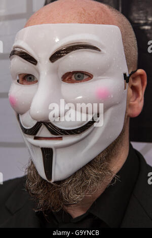 Belfast, UK, Europe. 4th July 2016. A man wearing a Guido Fawkes/Anonymous mask at the gates of Belfast City hall where protesters staged a rally Credit:  Bonzo/Alamy Live News Stock Photo