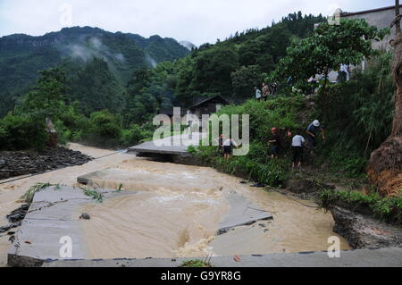 Tongren, China's Guizhou Province. 4th July, 2016. Villagers clear out a bypath beside a damaged road at Taiping Village in Tongren, southwest China's Guizhou Province, July 4, 2016. Continuous heavy rainfall has affected 140,000 residents in Tongren, and rain-triggered floods have also damaged crops, roads, telecommunication and electricity facilities. China's meteorological authority renewed its orange alert for heavy rain in the south and southwest of the country on Monday. Credit:  Xiang Dingjie/Xinhua/Alamy Live News Stock Photo