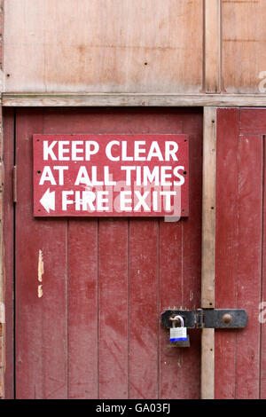 Locked wooden Fire Exit,  danger locked, old building, burn, heat, metal, rustic, safety, structure entrance sign, Keep Clear at all times, Manchester Stock Photo