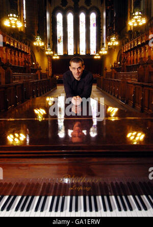 Janitor and virtuoso pianist Aleksander Kudajcyk with a piano at the Glasgow University Chapel. Stock Photo