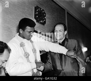 (L-R) World Heavyweight Champion Muhammad Ali throws a friendly left cross at challenger Henry Cooper as they meet in the Piccadilly Hotel, London, to publicise their fight Stock Photo