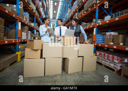 Managers are working in the middle of cardboard boxes Stock Photo