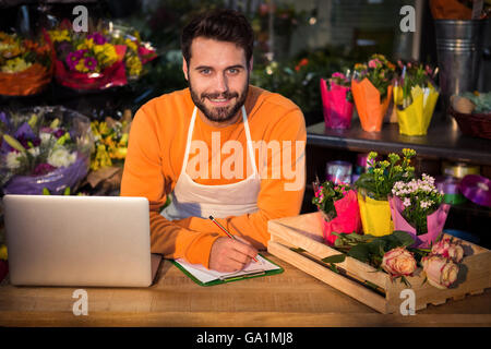Male florist noting order in notepad Stock Photo