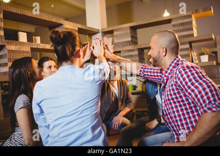 Colleagues giving high five at office Stock Photo