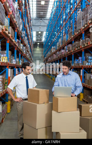 Managers working with a laptop put on a cardboard box Stock Photo