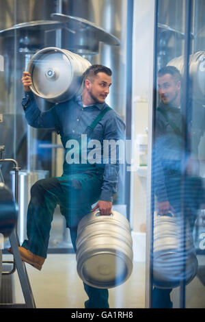 Brewer carrying keg Stock Photo