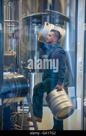 Brewer carrying keg Stock Photo