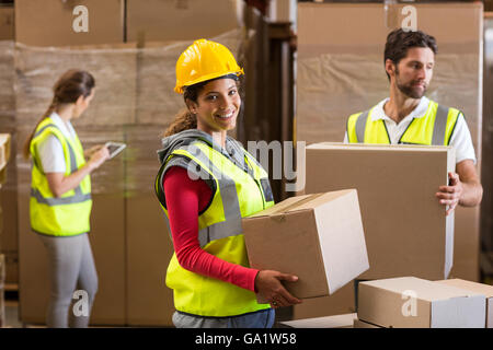 Focus of worker is holding goods and smiling to the camera Stock Photo