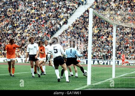 West Germany goalkeeper Sepp Maier (r) almost drops the ball into his own net, watched by teammates Paul Breitner (r, hidden) and Franz Beckenbauer (third r), as Holland's Rob Rensenbrink (c) waits to pounce Stock Photo