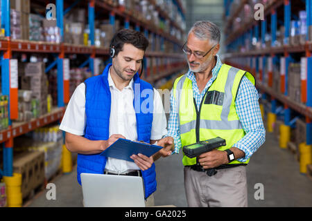 Workers colleague looking at digital tablet in warehouse Stock Photo