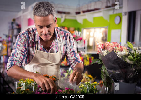 Male florist arranging bouquet of flower Stock Photo