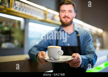 Waiter holding cup of coffee Stock Photo