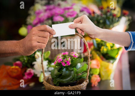 Florist giving visiting card to customer Stock Photo