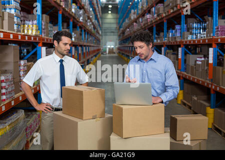 Managers working with a laptop put on a cardboard box Stock Photo