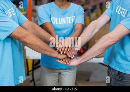 Close up of volunteers joining hands Stock Photo