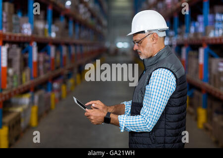 Side view of serious worker is using a tablet Stock Photo