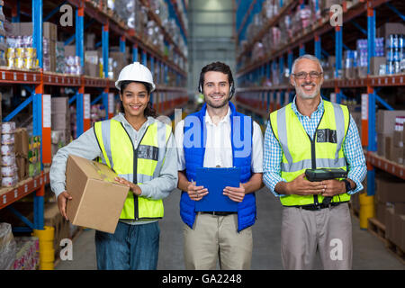 Warehouse workers looking at camera in warehouse Stock Photo