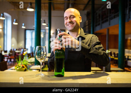 Waiter opening a bottle of white wine Stock Photo
