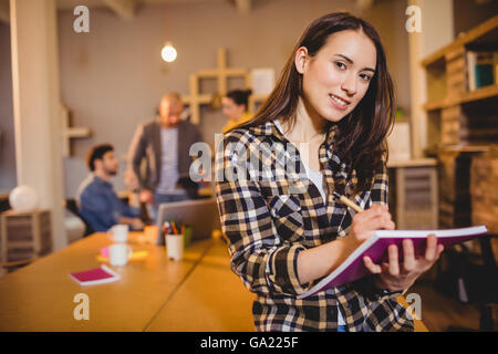 Graphic designer making notes in her diary Stock Photo