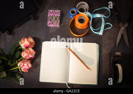 Open diary and florist accessories on the table Stock Photo