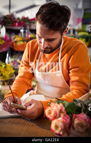Male florist noting order in dairy Stock Photo