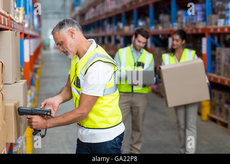 Focus of worker is working on cardboard boxes with his colleagues Stock Photo
