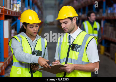 Workers looking at clipboard Stock Photo