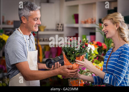 Florist giving bouquet of flower to woman Stock Photo