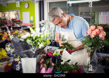 Male florist arranging flowers Stock Photo