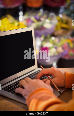 Male florist working on laptop Stock Photo