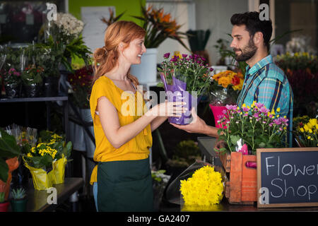 Female florist giving flower bouquet to man Stock Photo