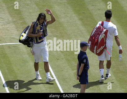 Spain's Rafael Nadal (left) acknowledges the crowd as Serbia's Novak Djokovic walks away dejected after the semi-final match during The All England Lawn Tennis Championship at Wimbledon. Stock Photo