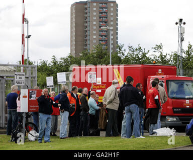 Postal workers leave a Royal Mail delivery office to begin the work of ...