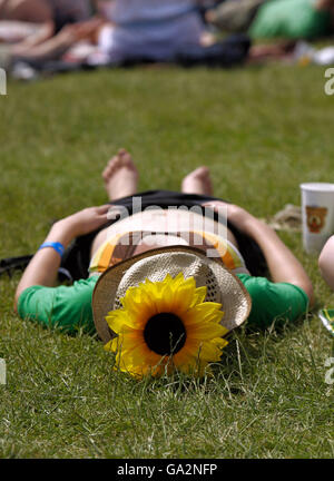 People sunbathe in the sunshine at the Isle of Wight Festival in Seaclose Park on the Isle of Wight. Stock Photo