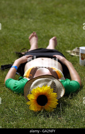 People sunbathe in the sunshine at the Isle of Wight Festival in Seaclose Park on the Isle of Wight. Stock Photo