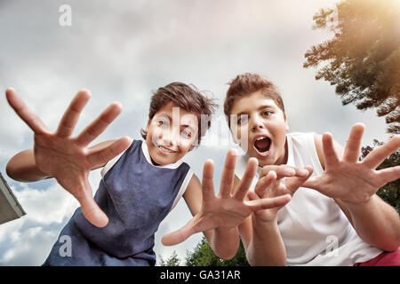 Two happy boys having fun outdoors, making faces to the camera, best friends enjoying holidays in a summer camp Stock Photo