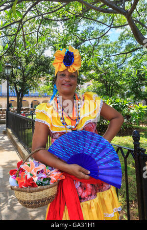 Cuban woman in colorful dress poses in Plaza de Armas, La Habana Vieja, Old Havana, Cuba Stock Photo