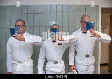 U.S Naval Academy incoming freshmen known as Plebes stand against a wall in Bancroft Hall reading their Reef Points during Induction Day June 30, 2016 in Annapolis, MD. Induction Day begins when the incoming plebes are issued uniforms, given medical examinations, complete registration, receive hair cuts and learn to salute. Stock Photo