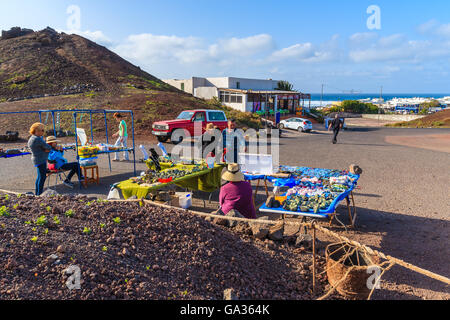 EL GOLFO, LANZAROTE ISLAND - JAN 15, 2015: tourists buying souvenirs in El Golfo village, Lanzarote, Canary Islands, Spain. This is very popular place to visit while spending holiday on the island. Stock Photo