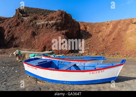 EL GOLFO BEACH, LANZAROTE - JAN 15, 2015: traditional fishing boats on beach near Lago Verde. El Golfo is a fishing village on western coast of Lanzarote island, Spain. Stock Photo