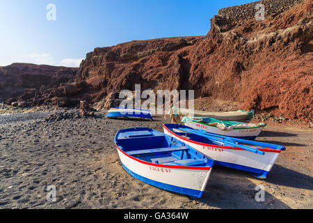 EL GOLFO BEACH, LANZAROTE - JAN 15, 2015: traditional fishing boats on beach near Lago Verde. El Golfo is a fishing village on western coast of Lanzarote island, Spain. Stock Photo