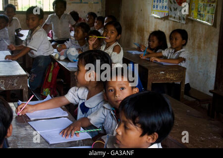 Young children are sitting at desks studying at a primary school in Chork Village, Cambodia. Stock Photo