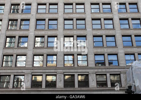 Reflections off the windows of a building on State Street in Chicago, IL, USA Stock Photo