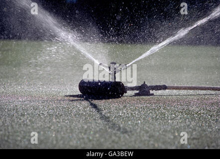 Commercial sprinkler irrigating golf course green; Kentucky; USA Stock Photo