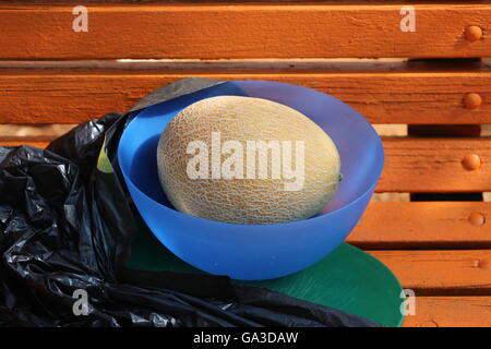 Unpeeled Melon Fruit in a Blue Plastic Bowl Stock Photo