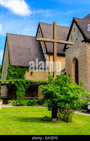Vreta, Sweden - June 20, 2016: An old wooden cross with part of Vreta cloister church in the background. Stock Photo