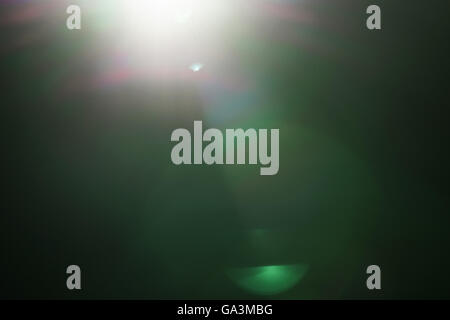 real green lens flare over dark background Stock Photo